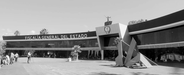Fachada de la sede de la Fiscalía General del Estado de Michoacán con vehículos oficiales estacionados al frente